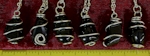 Apache Tears are a form of obsidian, and are black, translucent stones. Apache Tear Tumbled stones wire wrapped as pendants on necklaces.